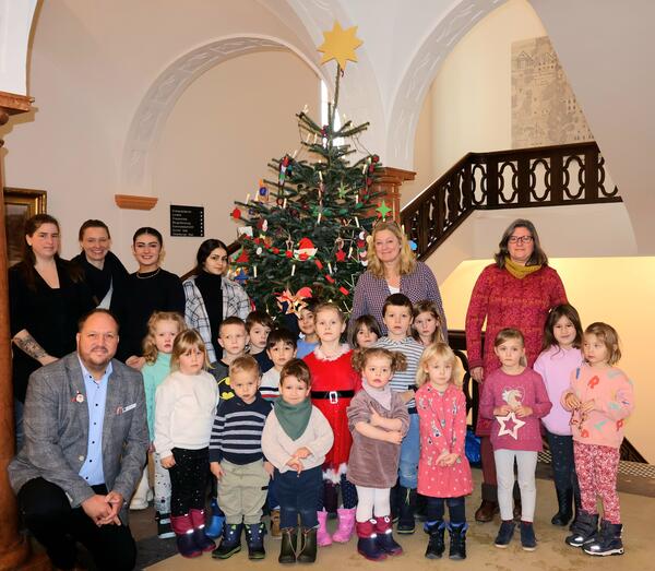 Landrat Gaarz und die Kinder und ihre Erzieherinnen vor dem geschmckten Weihnachtsbaum